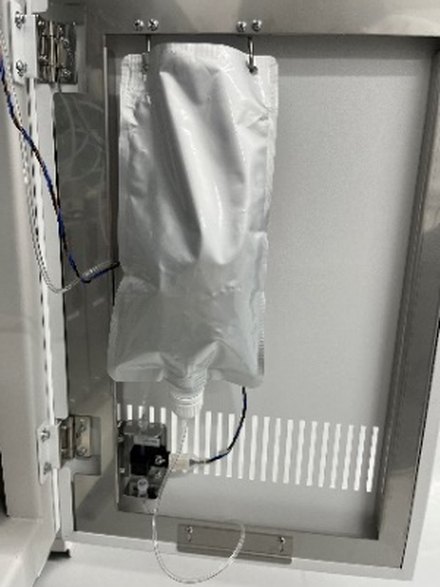 装置内部の扉を開けて撮った写真。バッグや配管、周りの部品が入り混じって写り込んでいる